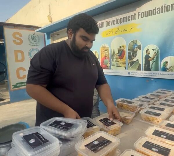 Volunteers arranging food packages for distribution to underprivileged families in Pakistan